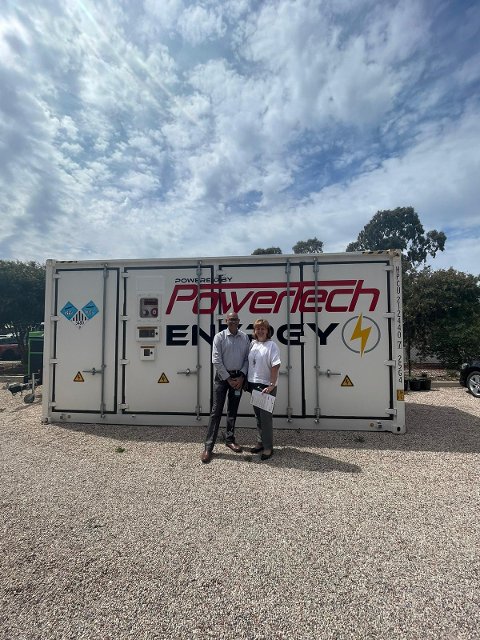 Ambasador Tyrer in front of a large-scale Battery at PowerTech Company in Adelaide
