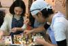 Mr. Shu SATO (Chef - Kodaira +6th elementary school) a ostatní účastníci kurzu vaření připravuje jednohubky