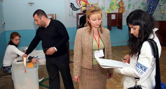 An ODIHR election observer speaks with an official at a polling station in Yerevan during parliamentary elections in Armenia, 12 May 2007. (OSCE/Urdur Gunnarsdottir)