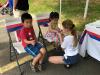 Children stop by the face painting table. 