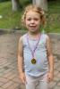 A girl proudly wears her gold medal - photo by Andrea Pohl