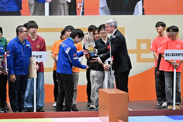 Handing over the cup to the winner of the Japanese round of the Robocon competition 2026