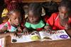 Central African schoolgirls read a primer in the local language Sango